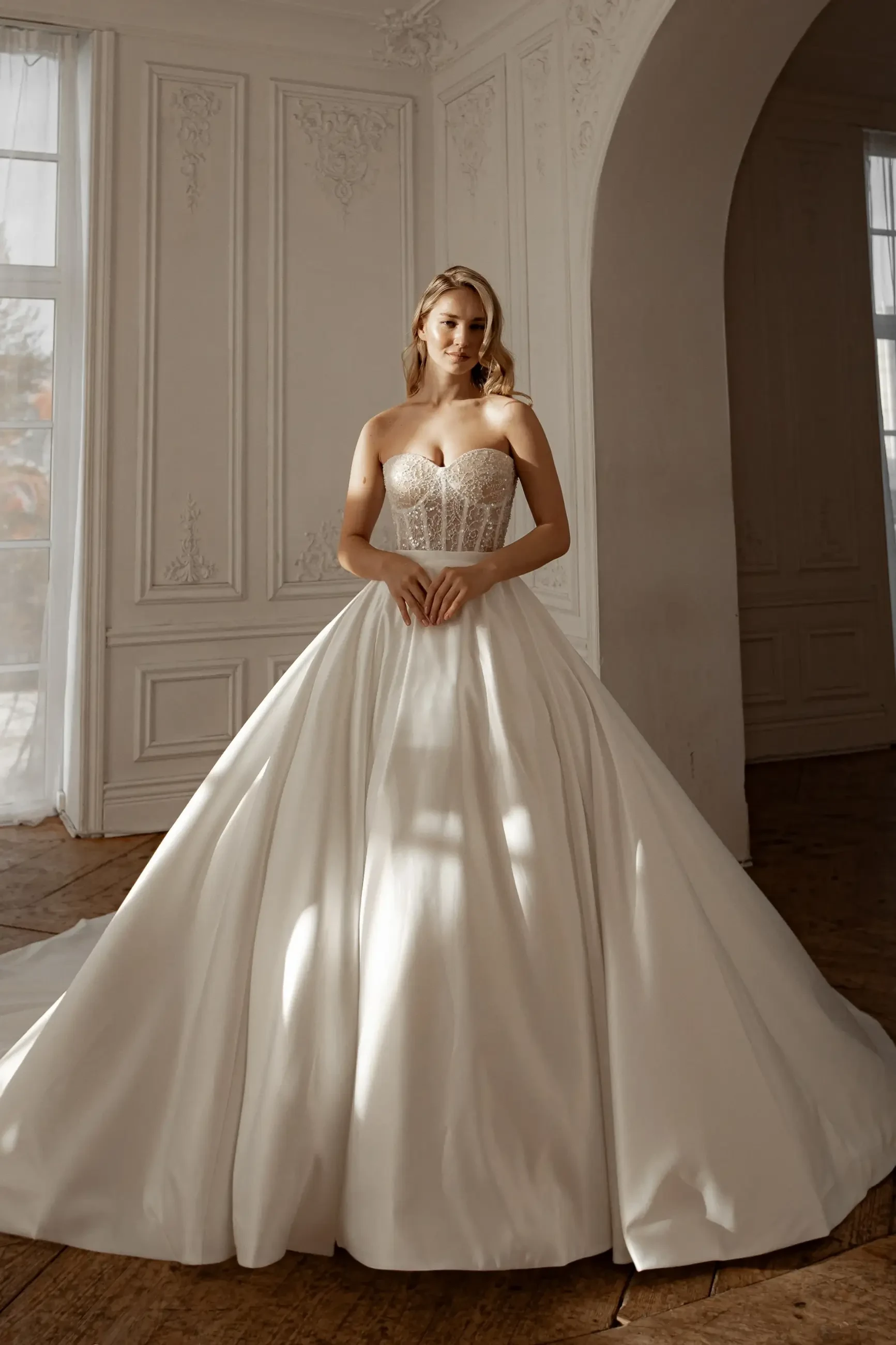 model is wearing a strapless ball gown with a detachable skirt