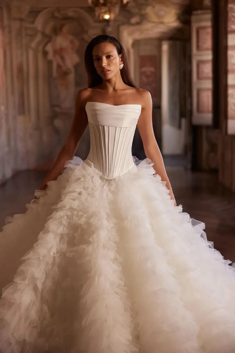 model is wearing a strapless wedding dress with a dropped waist and full skirt