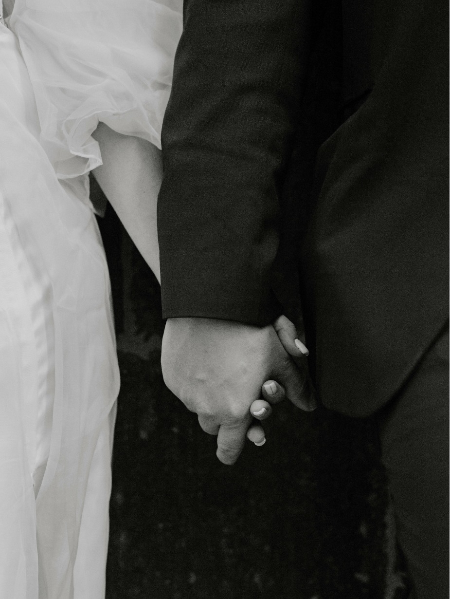Photo of the bride and groom holding their hands