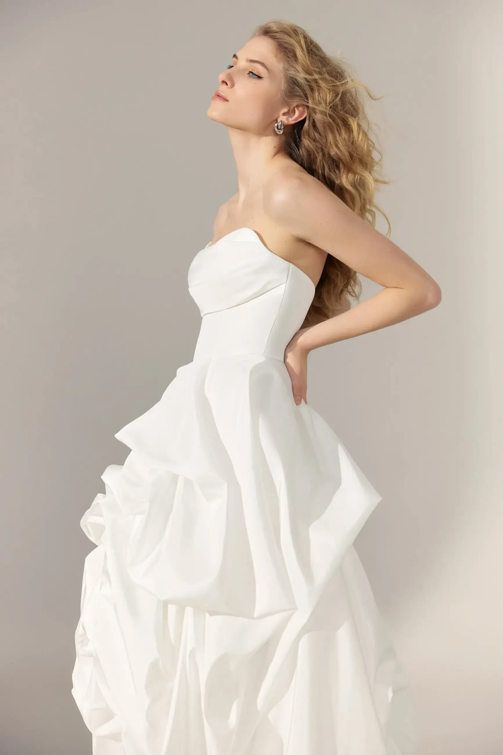 model is wearing a strapless ball gown wedding dress