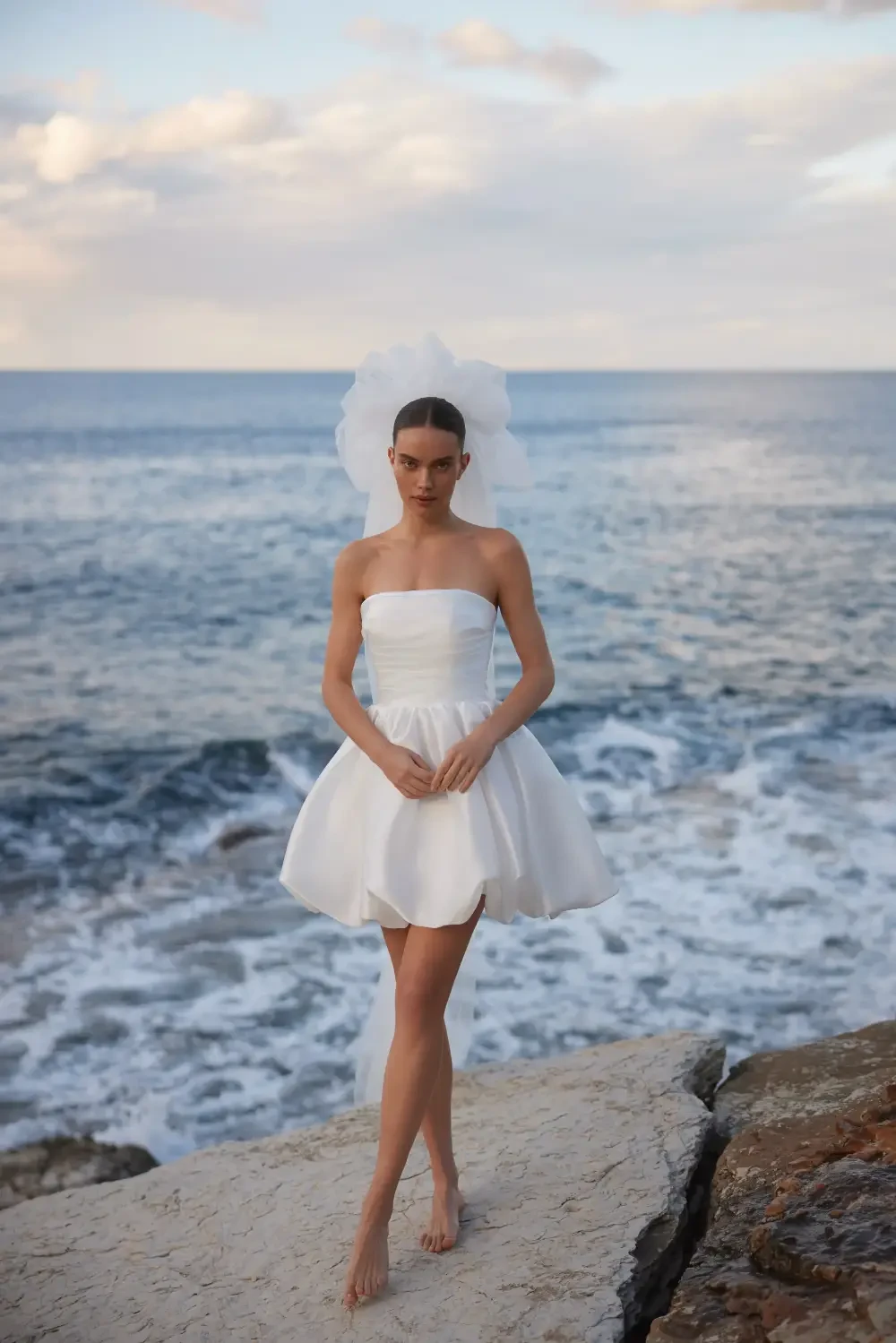 model is wearing a strapless mini bridal gown