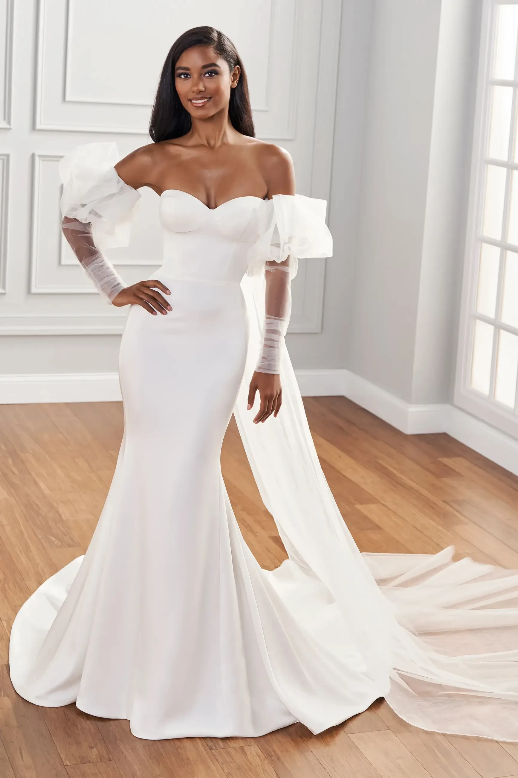 model is wearing an off the shoulder fit and flare wedding dress