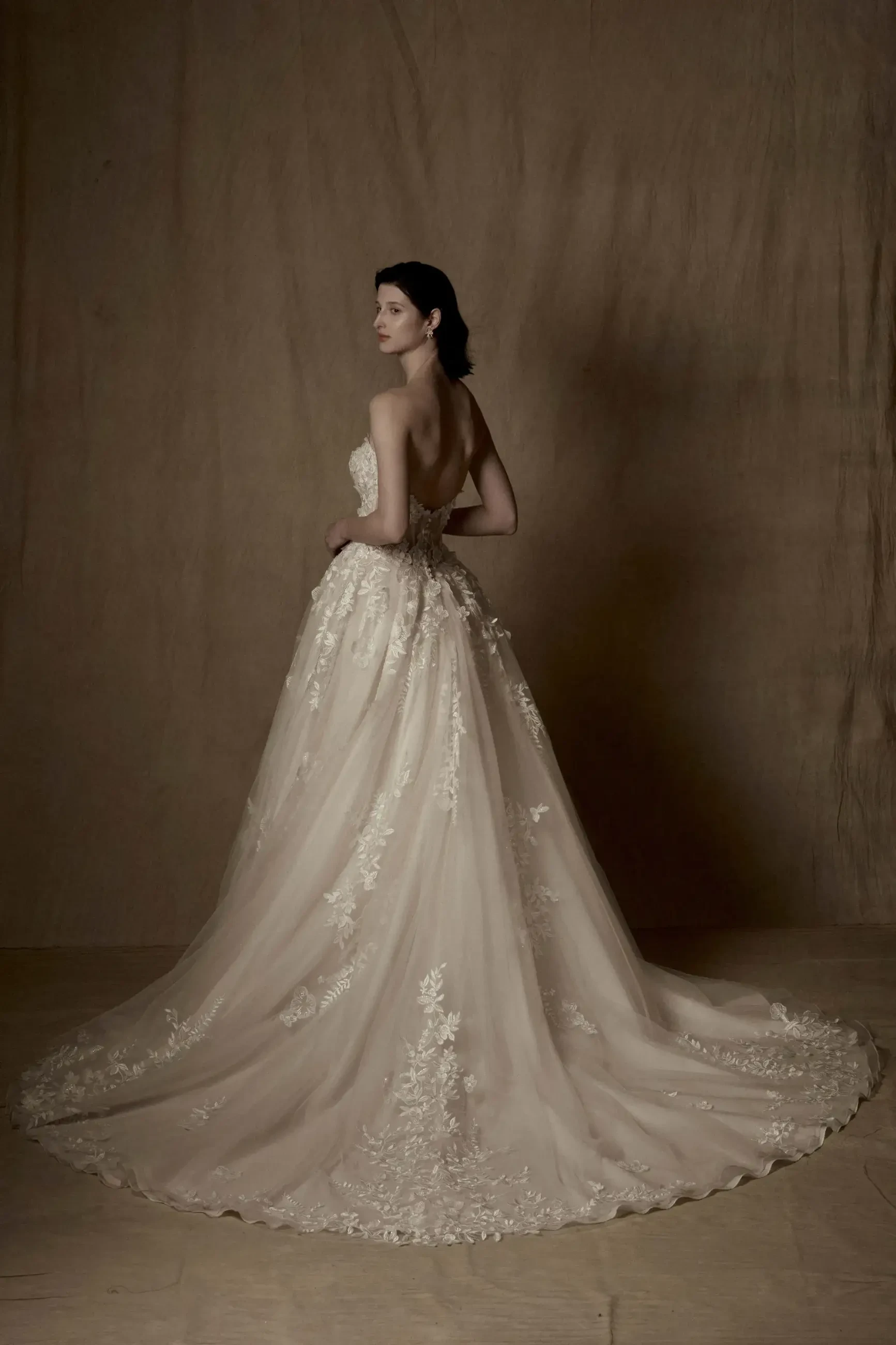 model is wearing a strapless ball gown wedding dress with 3d appliques