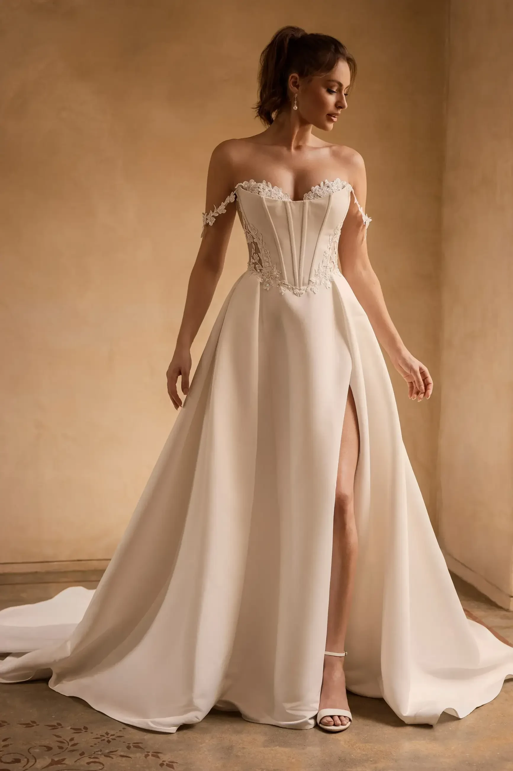 model is wearing an off the shoulder basque waist ball gown wedding dress